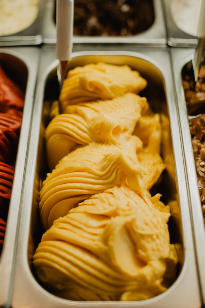 Zoomed view of creamy mango gelato scoops ready to be served.